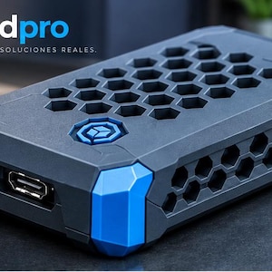 Può includere: Un involucro rettangolare per dispositivo elettronico in nero opaco con accenti blu brillante sugli angoli. La parte superiore e i lati presentano un motivo a nido d'ape esagonale. Un logo circolare è centrato e una porta HDMI è visibile.
