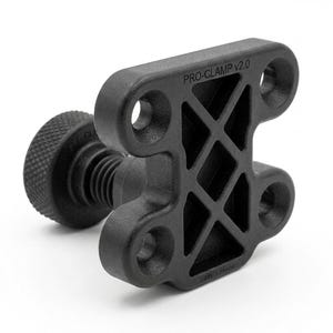 Puede incluir: Un soporte de montaje negro mate Pro-Clamp v2.0 con una base rectangular, cuatro orificios circulares para tornillos y una estructura de soporte en forma de cruz. Una perilla de ajuste roscada con agarre texturizado sobresale del centro.