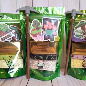 May include: Three green cellophane bags filled with gold-colored bars, glitter, and character stickers. Each bag has a pickaxe pencil and Minecraft-themed decorations. The bags are sealed with a zipper and are ready for gifting.