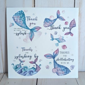 May include: White card with four circular designs featuring mermaid tails in shades of blue, pink, and purple. Text includes "Thank you," "Thanks for splashing by," and "Thanks for shellabrating with me."