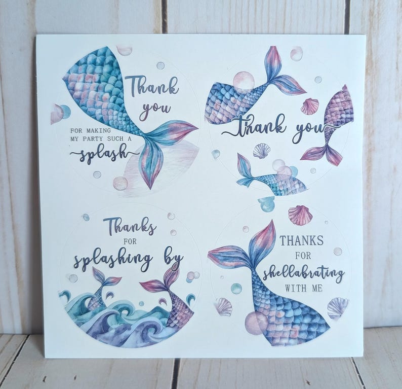 May include: White card with four circular designs featuring mermaid tails in shades of blue, pink, and purple. Text includes "Thank you," "Thanks for splashing by," and "Thanks for shellabrating with me."
