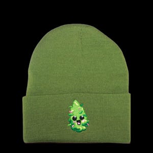 May include: A green beanie with a cute cartoon marijuana leaf embroidered on the front. The leaf has a smiling face and pink cheeks.