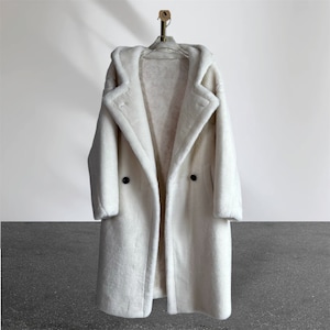May include: A white hooded shearling coat with a double-breasted closure and long sleeves.