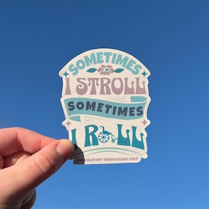 May include: A sticker with the text "Sometimes I Stroll, Sometimes I Roll" in purple and teal. The sticker has a flower and star design, and the words "Ambulatory Wheelchair User" are at the bottom.