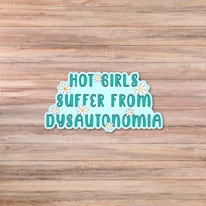 May include: A light blue sticker with the text "HOT GIRLS SUFFER FROM DYSAUTONOMIA" in a playful font. The sticker is decorated with white daisies and is set against a wooden background.
