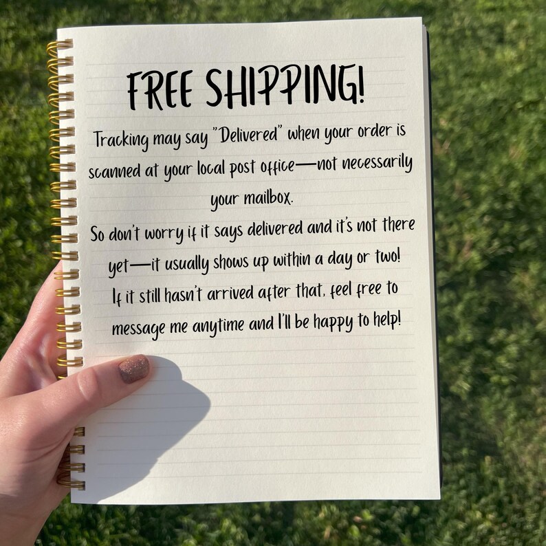 May include: A spiral-bound notebook with lined paper. The cover is not visible. The text "FREE SHIPPING!" is written at the top, followed by a message about order tracking. The notebook is held by a person.