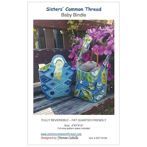 May include: A sewing pattern for a reversible baby bindel, measuring 4 inches by 4 inches by 10 inches. The bindel is made of blue and green fabric with a geometric pattern. The pattern is fat quarter friendly and includes a full-size pattern piece. The pattern is designed by Yvonne Cabella and is available on the website sisterscommonthread.com.