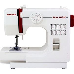May include: A white Janome "sew mini" sewing machine with red accents. The machine features a stitch selector dial, stitch pattern diagrams, and the brand name "Janome". The machine has a needle, a presser foot, and a small work surface.