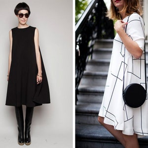 May include: Two women wearing dresses. The woman on the left is wearing a black sleeveless dress with black knee-high boots. The woman on the right is wearing a white dress with black geometric patterns and a black round crossbody bag.