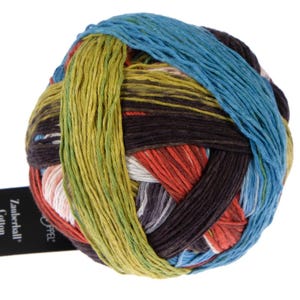 May include: A ball of colorful yarn with stripes of green, blue, red, brown, white, and gray. The yarn is labeled "Schachenmayr" and "Cotton"