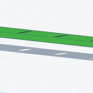 K&ouml;nnte beinhalten: Ein leuchtend gr&uuml;nes, geometrisches Objekt mit einer langen, rechteckigen Oberseite und zwei abgewinkelten St&uuml;tzen. Die Oberseite hat mehrere gleichm&auml;&szlig;ig verteilte, rechteckige Aussparungen. Das Objekt wirft einen Schatten.
