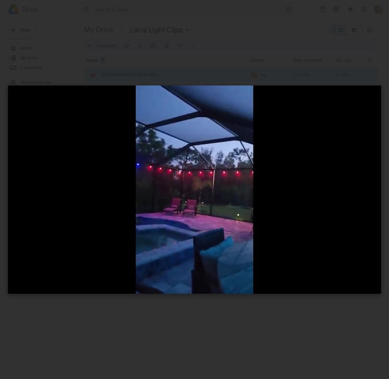 May include: Outdoor scene at dusk featuring a swimming pool, patio furniture, and string lights. The pool has blue and purple lighting. Red string lights are strung across the top of the patio. The sky is a dark blue.