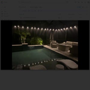 May include: Outdoor nighttime scene featuring a swimming pool with string lights overhead. The pool area includes lounge furniture, a table, and a covered patio. The lighting creates a relaxing ambiance for an evening gathering.
