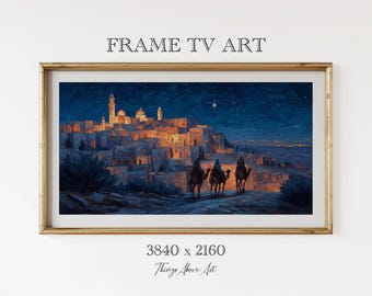 Op de afbeelding: Een ingelijste digitale kunstprint met een nachtelijke stadsgezicht met verlichte gebouwen onder een sterrenhemel. Drie figuren op kamelen staan op de voorgrond. De tekst "FRAME TV ART" en "Things Above Art" zijn zichtbaar.
