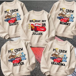 May include: A white ceramic mug with a black handle and the text "But First, Coffee" in a black, handwritten-style font. The mug is on a white surface.