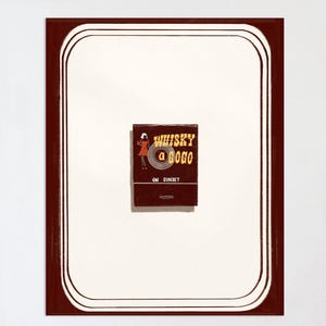 May include: A vintage matchbook with a red and white design. The matchbook features a woman in a red dress dancing with the text "Whisky a Go Go" and "On Sunset" printed on it.