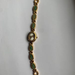 gold and green stones watch