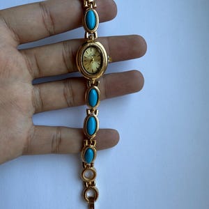 montre en or et pierres bleues