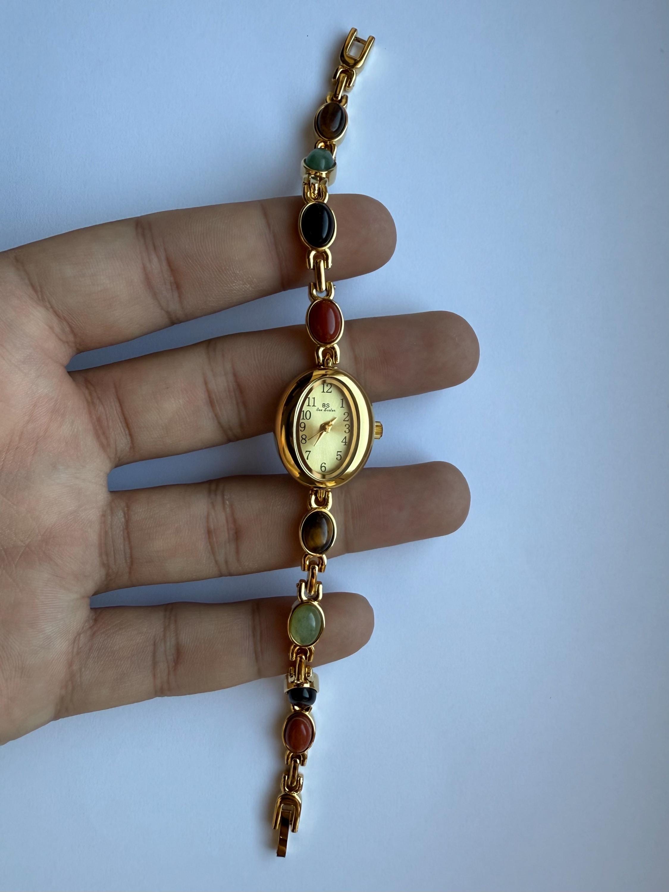 zierliche Uhr aus Gold und bunten Steinen