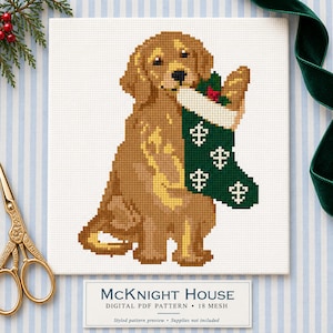 May include: A cross-stitch pattern featuring a golden puppy holding a green Christmas stocking with white snowflake motifs. The text reads McKnight House, Digital PDF Pattern, 18 Mesh, Styled pattern preview, Supplies not included.