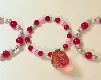 3 beaded Strawberry Shortcake theme bracelets with strawberry charm on one of the bracelets, to fit your 16” CPK doll or similar size doll.