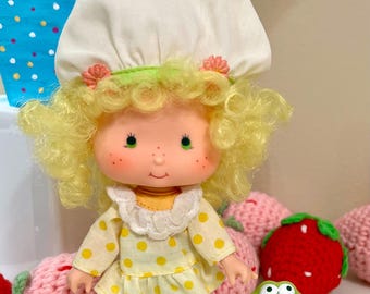 Strawberry Shortcake 1980’s American Greetings Lemon Meringue Doll with her pet, Frappe Frog.