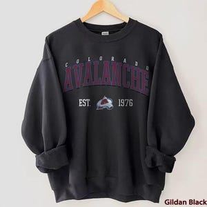May include: Black sweatshirt featuring a Colorado Avalanche logo and the text "Colorado Avalanche Est. 1976".