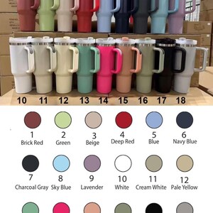 Może przedstawiać: Kolekcja izolowanych kubk&oacute;w podr&oacute;żnych w r&oacute;żnych kolorach, w tym ceglastoczerwonym, zielonym i granatowym. Każdy kubek ma uchwyt i pokrywkę. Dostępne kolory są oznaczone numerami i nazwami.