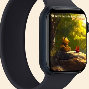 May include: A black Apple Watch with a black sport band. The watch face displays a cartoon image of Winnie the Pooh sitting on a rock in a forest with the text "It never hurts to keep looking for sunshine."