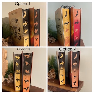 Puede incluir: Cuatro opciones diferentes para el dise&ntilde;o de la portada de un libro. El libro se titula "The Fourth Wing" y presenta un dise&ntilde;o de drag&oacute;n en el lomo. Las opciones incluyen un fondo dorado con dragones negros, un fondo rojo con dragones dorados, un fondo negro con dragones dorados y un fondo negro con dragones naranjas.