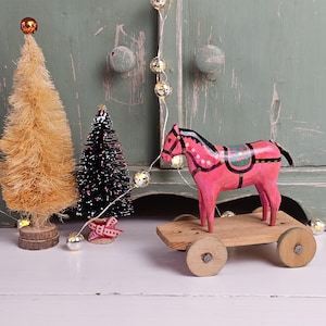 Antique small pink toy horse on wheels