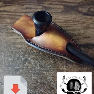 May include: A brown leather pipe pouch with a black pipe inside. The pouch has a stitched edge and a logo that says "Scarab Leatherworks" with a beetle design.