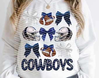 May include: White sweatshirt with a blue and white football helmet, football, and bow design. The text "COWBOYS" is printed in black on the front of the sweatshirt.