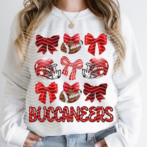 May include: White sweatshirt with a red and white design featuring football helmets, footballs, and bows. The text "BUCCANEERS" is printed in red on the front of the sweatshirt.