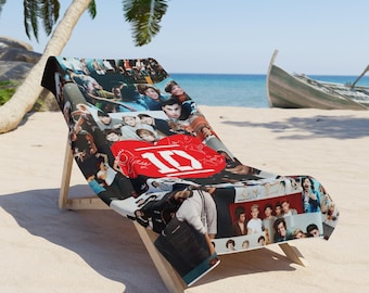 May include: A beach chair with a black and white beach towel featuring a collage of photos of a boy band. The towel has a red heart with the number "1D" inside.