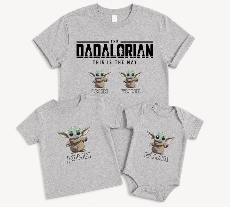 K&ouml;nnte beinhalten: Vier hellgraue T-Shirts und ein Body. Das gr&ouml;&szlig;te Shirt tr&auml;gt die Aufschrift "THE DADALORIAN THIS IS THE WAY" mit Cartoon-Bildern eines gr&uuml;nen Aliens. Die anderen Shirts und der Body zeigen den Alien und Namen.