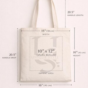 Puede incluir: Gu&iacute;a de tallas de un bolso tote beige. El bolso mide 38 cm de ancho y 41 cm de alto, con una ca&iacute;da de asa de 52 cm. El &aacute;rea de impresi&oacute;n es de 25,4 x 30,5 cm. La longitud del asa es de 52 cm.