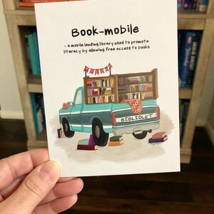 May include: A greeting card with the text "Book-mobile" and a definition. The illustration shows a teal truck filled with books, labeled "BIBLIOLET". Several books are scattered around the truck.