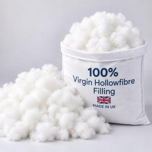 Puede incluir: Una bolsa de tela blanca rellena de material de fibra hueca blanco y esponjoso. La bolsa presenta el texto 100% Virgin Hollowfibre Filling, un pequeño icono de la bandera británica y el texto MADE IN UK impresos en azul oscuro.