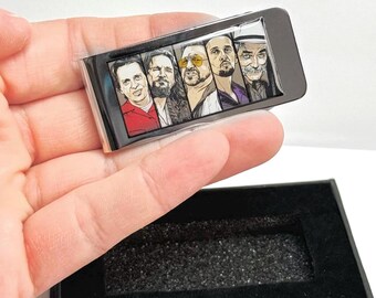 May include: A silver money clip with a colorful image of five men's faces. The clip is in a black box with a black velvet lining.