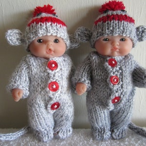May include: Two gray knitted monkey doll outfits with red and white striped hats. The outfits have red buttons and a tail.