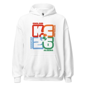 May include: White hooded sweatshirt with a colorful graphic design. The design features a soccer ball and the text "KG 26" with the names of countries: England, Netherlands, Argentina, and Algeria.