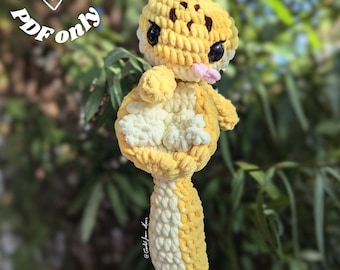 May include: A handmade, yellow and white crocheted gecko plushie with black eyes and a pink tongue. The gecko has brown spots on its head and is hanging from a green leafy branch. Text in a circle reads "Digital file PDF only".