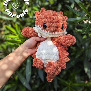 Op de afbeelding: Gehaakte knuffel van een baardagaam in oranje en wit. Het speelgoed heeft grote zwarte ogen en een witte kraag. De tekst "Digital file only" staat in een cirkel boven de knuffel.