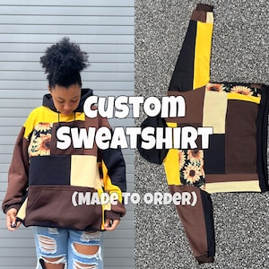 Może przedstawiać: Spersonalizowana bluza typu patchwork ze wzorami słoneczników i geometrycznymi w kolorach brązowym, czarnym, żółtym i kremowym. Tekst "CUSTOM SWEATSHIRT (MADE TO ORDER)" jest wyświetlany na biało. Bluza z kapturem ma przednią kieszeń i kaptur.