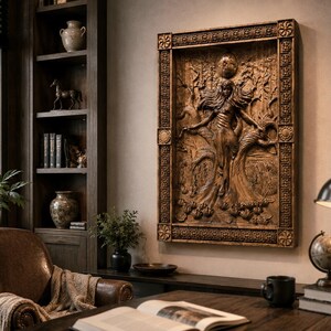 May include: A detailed, brown wooden relief carving of a woman with outstretched arms, set within a decorative frame. The artwork is mounted on a wall in a room with a desk, bookshelves, and a leather armchair. The room is well-lit with natural light.