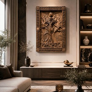 May include: A detailed, brown wooden relief sculpture of a figure with outstretched arms, set within an ornate rectangular frame. The artwork is mounted on a neutral-toned wall, part of a modern living room interior.