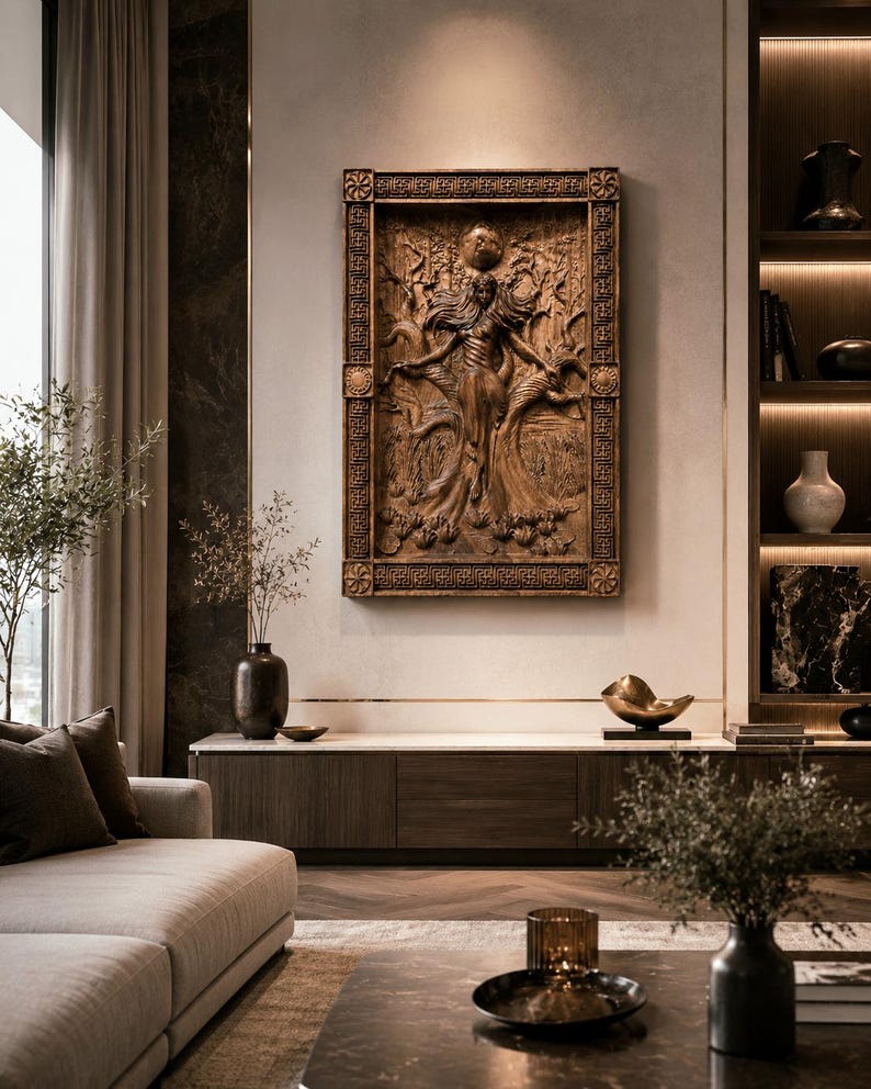 May include: A detailed, brown wooden relief sculpture of a figure with outstretched arms, set within an ornate rectangular frame. The artwork is mounted on a neutral-toned wall, part of a modern living room interior.