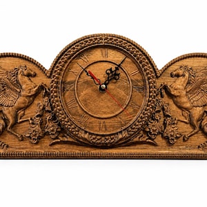 May include: Wooden mantel clock with a carved design. The clock features a round face with Roman numerals and a red second hand. Flanking the clock face are two carved winged horses. The clock is made of a light brown wood.