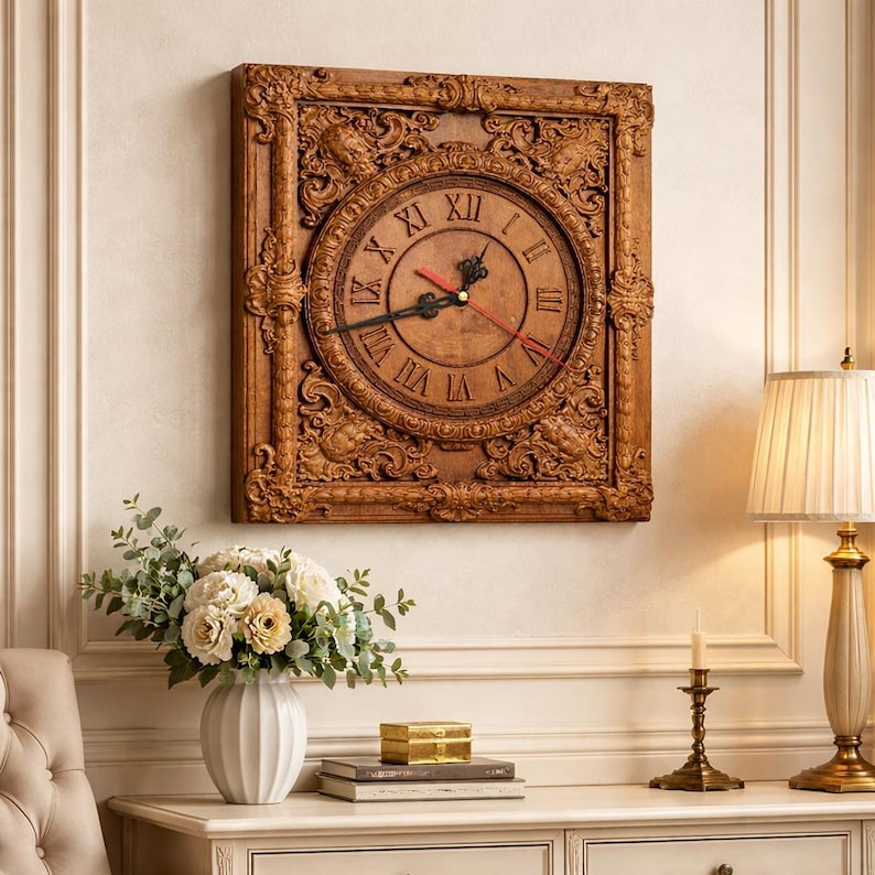 May include: A square, wooden wall clock with an ornate, carved frame. The clock face is a lighter shade of brown with Roman numerals and black hands, and a red second hand. The clock is mounted on a cream-colored wall.